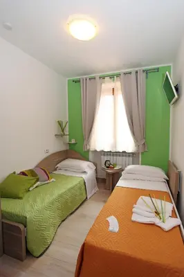two beds in a room with green walls at La Casa Felice a San Pietro in Rome