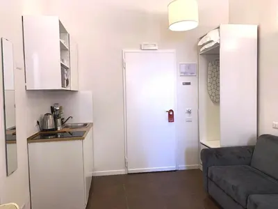 a kitchen with a refrigerator and a couch in a room at Eccelso Suites in Rome