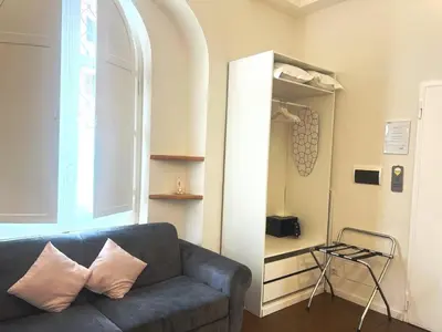 a living room with a blue couch and a window at Eccelso Suites in Rome