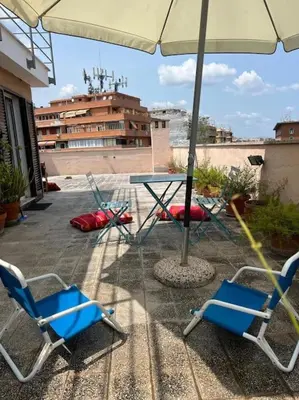 a patio with chairs and a table and an umbrella at Appartamento con ampio Terrazzo in Rome
