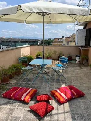 a patio with a table and chairs and an umbrella at Appartamento con ampio Terrazzo in Rome