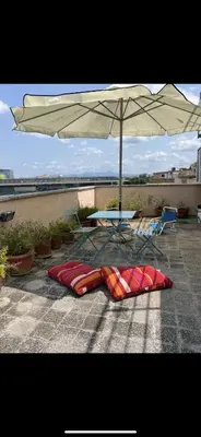 a table and chairs and an umbrella on a patio at Appartamento con ampio Terrazzo in Rome