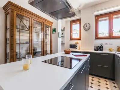 a kitchen with a large white counter top and windows at The Best Rent - Apartment in Trastevere area in Rome