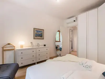 a white bedroom with two beds and a dresser at The Best Rent - Apartment in Trastevere area in Rome