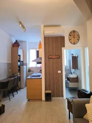 a kitchen and living room with a clock on the wall at Vintage House in Rome