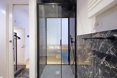 a glass shower door in a bathroom with at Youroom Quattro Fontane Appartamento in Rome
