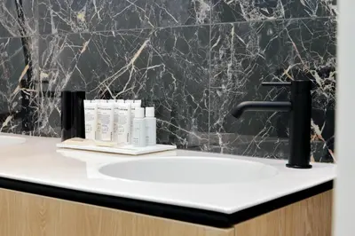 a bathroom with a sink and a black wall at Youroom Quattro Fontane Appartamento in Rome