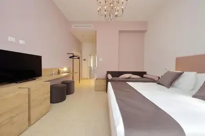 a bedroom with a large bed and a flat screen tv at Youroom Quattro Fontane Appartamento in Rome