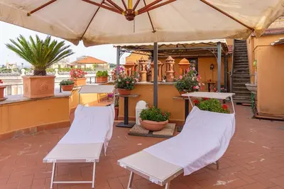 two white chairs and an umbrella on a patio at BrandNew House on the Terrace in Rome