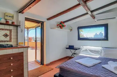 a small bedroom with a bed and a kitchen at BrandNew House on the Terrace in Rome