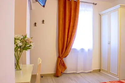an orange curtain in a room with a table at La Suite di San Pietro in Rome