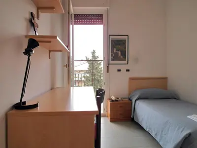 a bedroom with a bed and a desk with a lamp at Casa per Ferie Opera Don Calabria in Rome
