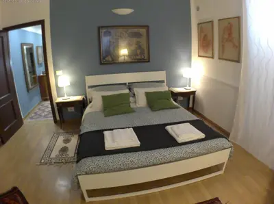 a bedroom with a large bed with two green pillows at LILIUM HOUSE Apts in Rome