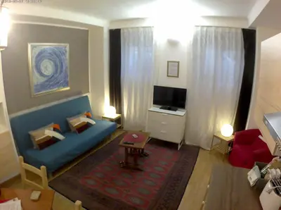 a living room with a blue couch and a television at LILIUM HOUSE Apts in Rome