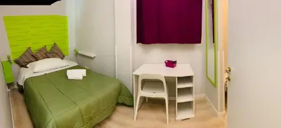 a small room with a bed and a small table at NASONI DI ROMA (VICINISSIMO BASILICA SAN GIOVANNI IN LATERANO) in Rome