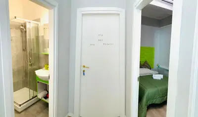a bathroom with a door leading to a bedroom at NASONI DI ROMA (VICINISSIMO BASILICA SAN GIOVANNI IN LATERANO) in Rome