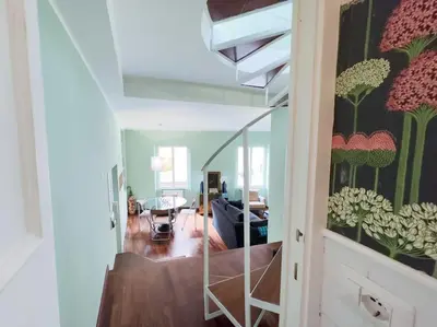 a living room with a staircase with a painting of flowers at Casa Triunfo Boutique Apartment in Rome