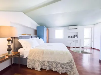 a bedroom with a bed and a table and a lamp at Casa Triunfo Boutique Apartment in Rome