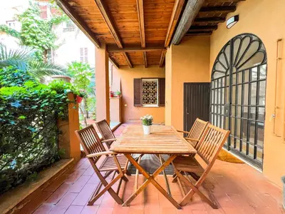 a wooden table and chairs on a patio at [Luxury House & Secret Garden] - Strategic location, 100m to Metro B in Rome