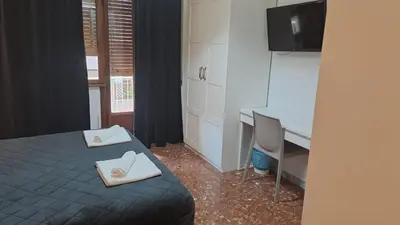 a bedroom with a bed and a desk with a computer at IN ROMA LIFE in Rome