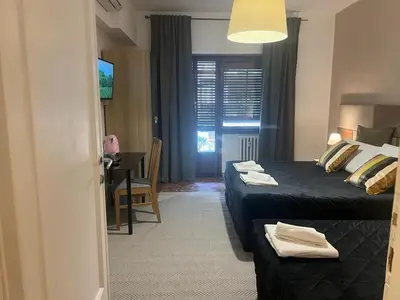 a hotel room with two beds and a table and a desk at IN ROMA LIFE in Rome