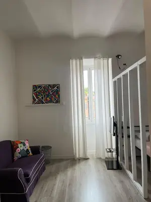 a living room with a couch and a window at Colosseo Living Suites in Rome