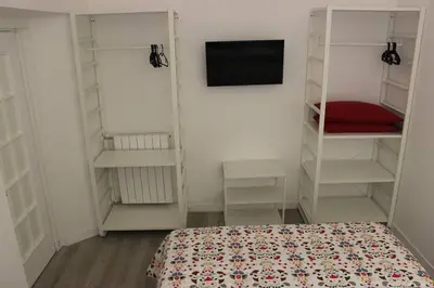 a bedroom with a bed and a tv and shelves at Colosseo Living Suites in Rome