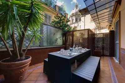 a patio with a table and a potted plant at Lh Royal Suites Terrace in Rome