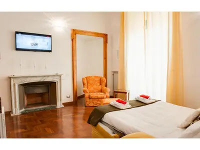a bedroom with a chair and a bed and a fireplace at Lh Royal Suites Terrace in Rome