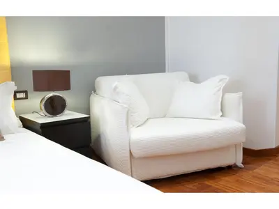 a white chair in a room with a bed at Lh Royal Suites Terrace in Rome