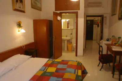 a hotel room with a bed and a bathroom at Le Rose di Bi in Rome