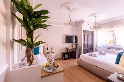 a room with a bed and a palm tree in it at Trastevere Paper Suites in Rome