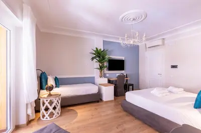 a living room with two beds and a tv at Trastevere Paper Suites in Rome