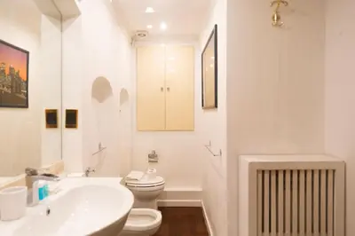 a white bathroom with a toilet and a sink at La dolce Silla - Appartamenti al Vaticano,Via Silla 91 in Rome
