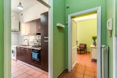 a kitchen with green walls and an open door at Lovely flat in Testaccio in Rome