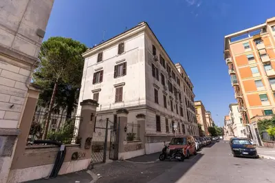a white building with cars parked on the side of a street at Lovely flat in Testaccio in Rome
