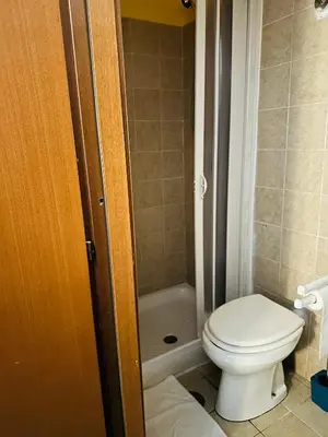 a small bathroom with a toilet and a shower at Magenta Roma house in Rome