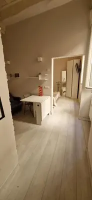 an empty room with a wooden floor and a white desk at Savelli Apartment Old Town - near Navona Place in Rome