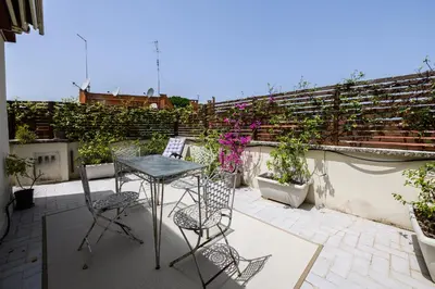 a patio with a table and chairs on a balcony at Rooftop Porretta Città Giardino Check-in From 3 Pm To 10 Pm in Rome