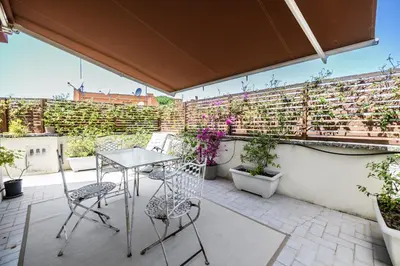 a patio with a table and chairs on a balcony at Rooftop Porretta Città Giardino Check-in From 3 Pm To 10 Pm in Rome