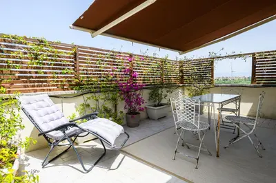 a patio with chairs and a table and some plants at Rooftop Porretta Città Giardino Check-in From 3 Pm To 10 Pm in Rome
