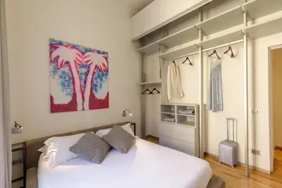 a bedroom with a bed and a painting of palm trees at Porta Castello Charme in Rome