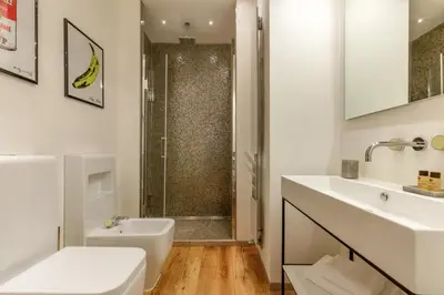 a white bathroom with a shower and a sink at Porta Castello Charme in Rome