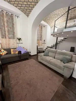 a living room with two couches and a staircase at la rosa di roma colosseo in Rome