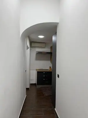 a room with a hallway with a kitchen with a counter at la rosa di roma colosseo in Rome