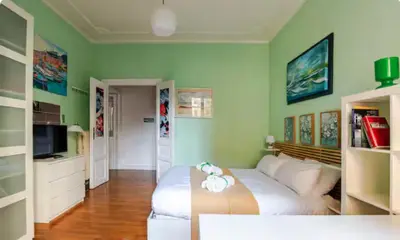 a bedroom with a large white bed and green walls at Green Window Roma in Rome
