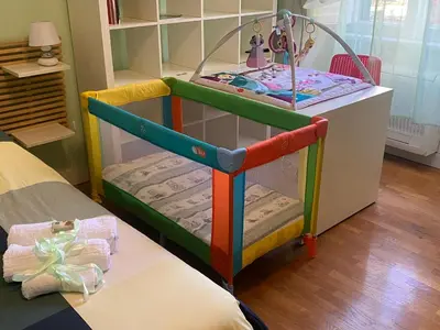a crib in a room with a table at Green Window Roma in Rome