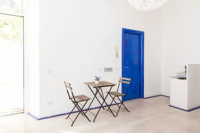 a table and chairs in a room with a blue door at Casa Maplink in Rome