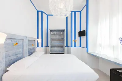 a blue and white bedroom with a bed and a chandelier at Casa Maplink in Rome