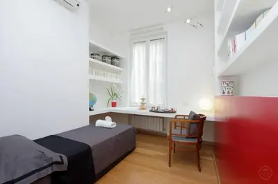 a bedroom with a bed and a chair and a window at Karol Apartment Rome in Rome